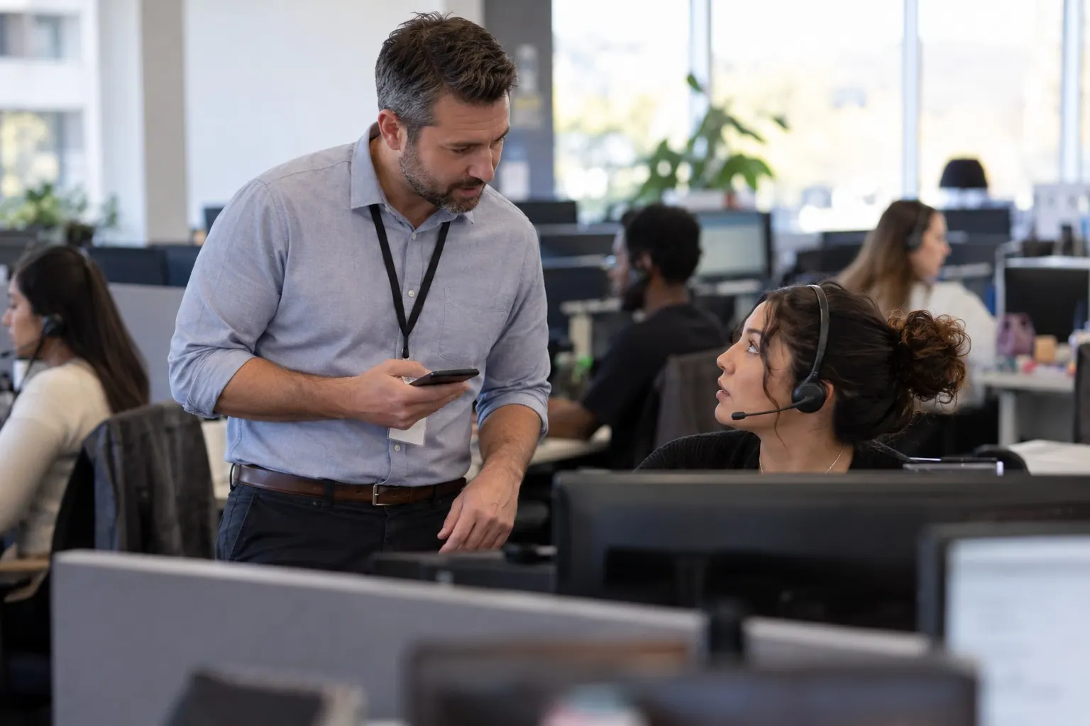 A call-center supervisor checks an alert with an agent before interpreting a shift in confirmation activity.