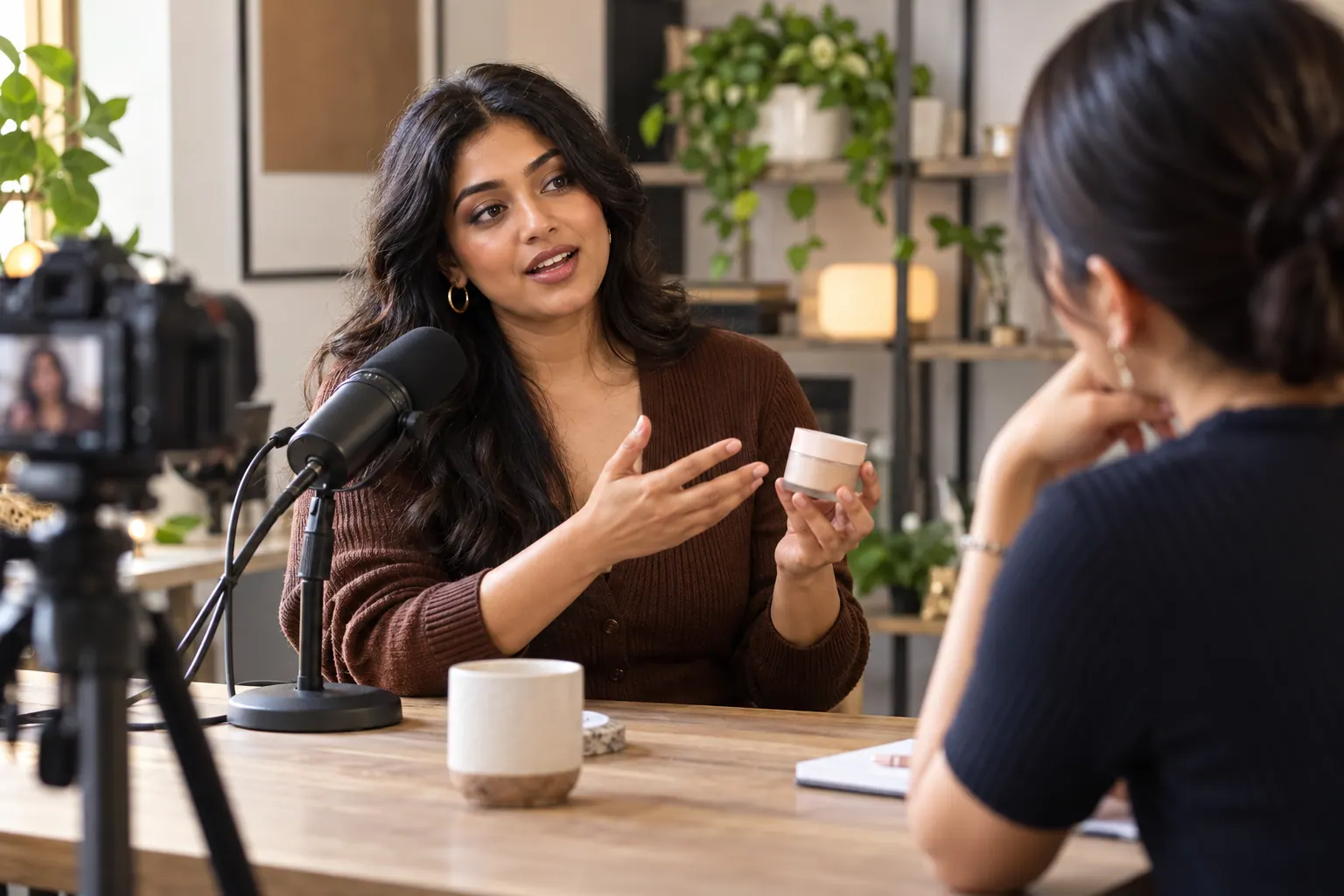 A beauty creator shares a product experience during a recorded conversation in a community studio.