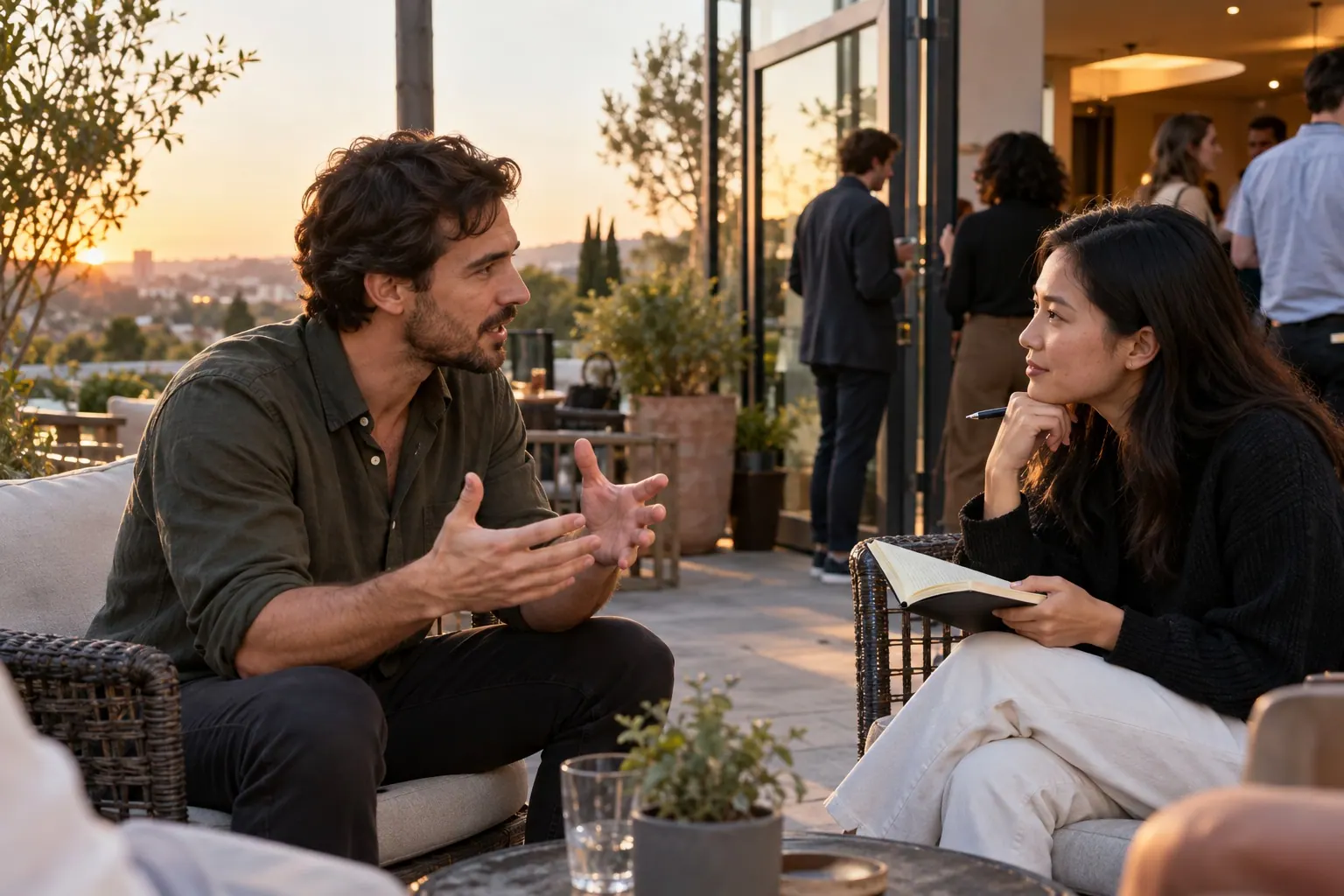 A facilitator speaks with a participant holding a notebook after a small outdoor workshop.